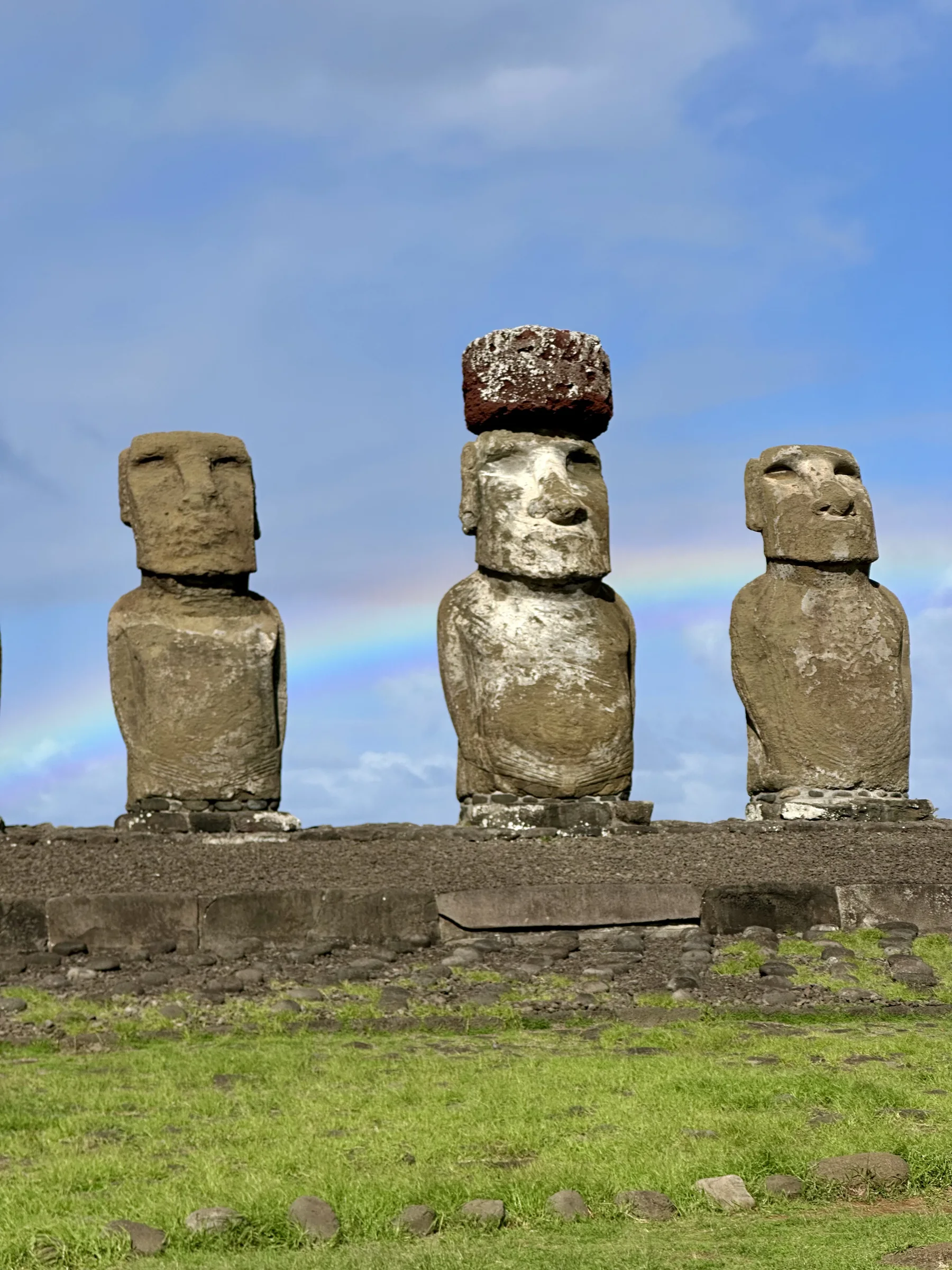 Tres moáis con un arcoíris al fondo